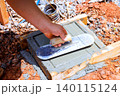 Worker levels fresh concrete with trowel on wooden frame at construction site 140115124