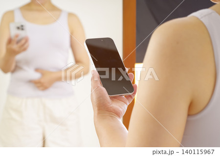 スマホで体型管理をする女性 スマホで体型管理をする女性 140115967