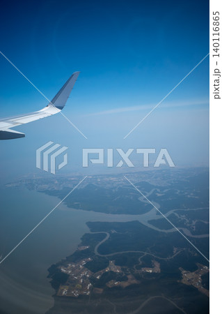 飛行機の窓から見下ろす蛇行する川と海岸線の空撮 飛行機の窓から見下ろす蛇行する川と海岸線の空撮 140116865