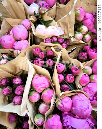 A multitude of bouquets of pink peonies wrapped in kraft paper A multitude of bouquets of pink peonies wrapped in kraft paper 140117136