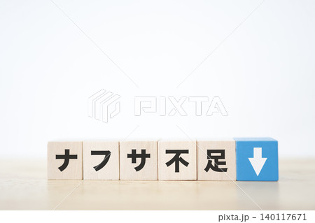ナフサ不足。石油由来製品の供給不足。下矢印。木製ブロック。白背景 140117671
