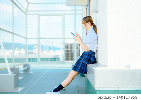制服の少女、スマホ操作 140117959