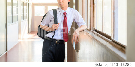 廊下で窓の外を見る男子学生 廊下で窓の外を見る男子学生 140118280