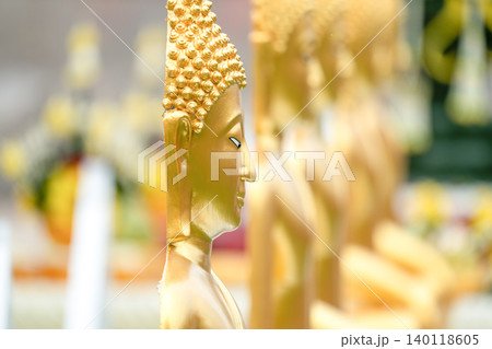 A golden Buddha relief on a Thai temple gable creates a strong cultural visual, combining sacred architecture with refined ornamental craftsmanship. 140118605