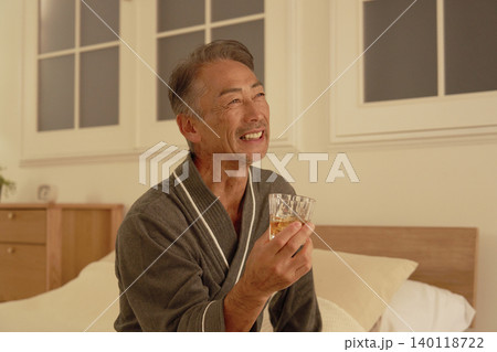 寝室でウイスキーを飲むシニア男性　ポートレート 140118722