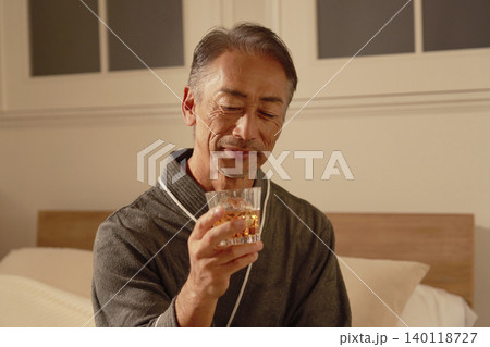 寝室でウイスキーを飲むシニア男性 140118727
