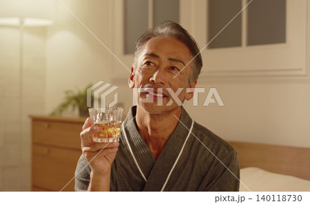 寝室でウイスキーを飲むシニア男性 140118730