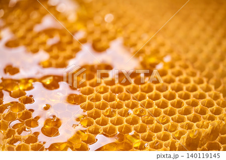 Macro shot of honey drop dripping from the honeycomb. A macro shot viscous honey, 140119145