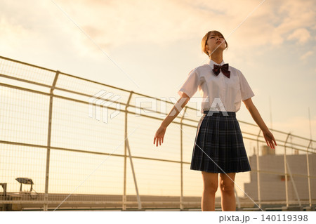 夕日を浴びる制服の少女 140119398