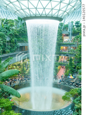Rain Vortex, the world's tallest indoor waterfall at Jewel Changi Airport. Green forest in mall and skytrain. Iconic landmark destinations at Singapore Changi Airport Rain Vortex, the world's tallest indoor waterfall at Jewel Changi Airport. Green forest in mall and skytrain. Iconic landmark destinations at Singapore Changi Airport 140120577