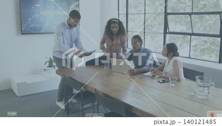 Discussing team in business casual reviewing laptop and tablet at modern office meeting room 140121485