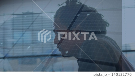 Leaning profile man in sweater studying monitor at office desk, with glass wall and grid overlay Leaning profile man in sweater studying monitor at office desk, with glass wall and grid overlay 140121770