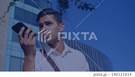 Speaking man wearing white shirt and shoulder bag in city, holding smartphone and wired earphones Speaking man wearing white shirt and shoulder bag in city, holding smartphone and wired earphones 140121814