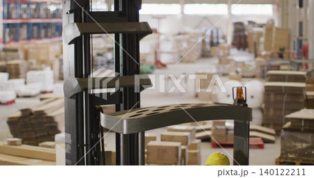 Framing forklift mast or carriage in warehouse, crew in hi-vis checking amber beacon and yellow helm Framing forklift mast or carriage in warehouse, crew in hi-vis checking amber beacon and yellow helm 140122211