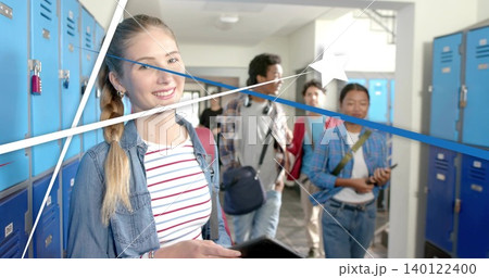 Standing blonde teen in striped tee denim jacket holding tablet in school hallway with blue lockers 140122400