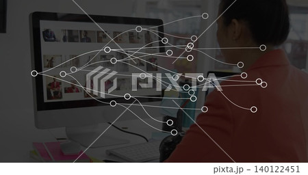 Reviewing woman in coral-blazer scrolling monitor thumbnails at desk with DSLR, nodes, copy space Reviewing woman in coral-blazer scrolling monitor thumbnails at desk with DSLR, nodes, copy space 140122451