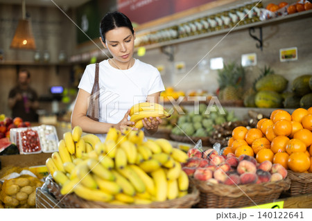 Woman choosing ripe bananas 140122641