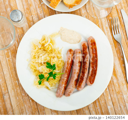Sausages served with sauerkraut, bread and parsley Sausages served with sauerkraut, bread and parsley 140122654