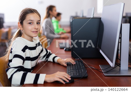 Portrait of schoolgirl at computers in university computer class Portrait of schoolgirl at computers in university computer class 140122664