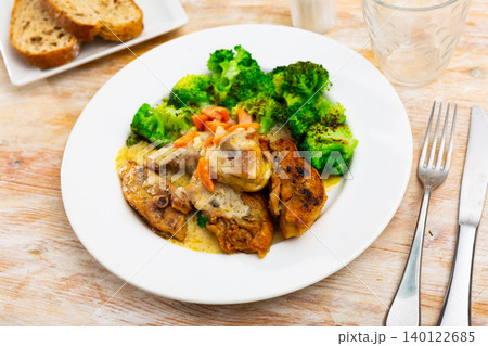 Pieces of chicken stewed in creamy sauce complemented with boiled broccoli. 140122685
