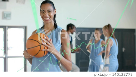 Smiling woman holding basketball standing front gym, with light blue jerseys and green overlay Smiling woman holding basketball standing front gym, with light blue jerseys and green overlay 140122775