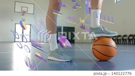 Balancing female athlete's legs resting on basketball in gym, wearing sneakers, socks, AR graphics 140122776