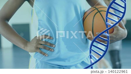 Holding orange basketball, player in light blue jersey, shorts posing at gym with blue DNA overlay 140122961