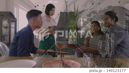 Leaning forward adult man operating laptop at home dining table, wearing dark shirt, copy space 140123177