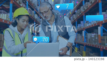 Pointing hardhat hi-vis staff viewing laptop, lead reading clip mic in warehouse with blue alerts 140123198