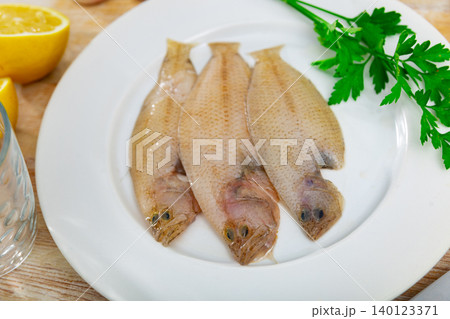 Spotted flounder served with parsley on plate Spotted flounder served with parsley on plate 140123371