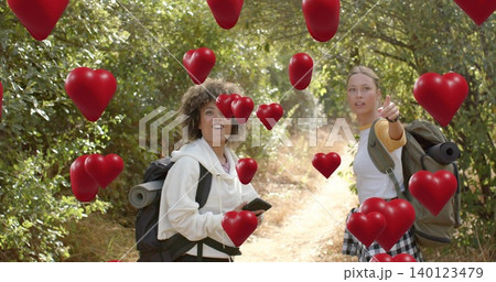 Pointing holding duo on woods dirt trail wearing hoodie packs rolled mats phone floating red hearts Pointing holding duo on woods dirt trail wearing hoodie packs rolled mats phone floating red hearts 140123479