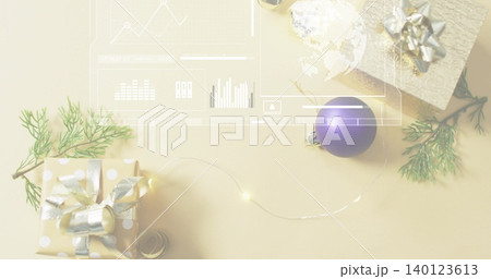 Arranging festive cluster on kraft desk: polka-dot box, metal wrap, purple bauble, lights, overlay 140123613