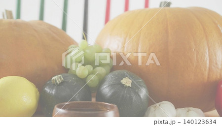 Displaying autumn produce sitting on tabletop, showing pumpkins, grapes, squashes, lemon, garlic Displaying autumn produce sitting on tabletop, showing pumpkins, grapes, squashes, lemon, garlic 140123634