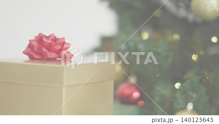 Displaying gold gift box with glossy red bow sitting on living-room table, warm lights, copy space Displaying gold gift box with glossy red bow sitting on living-room table, warm lights, copy space 140123643