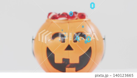 Displaying orange jack-o'-lantern bucket holding red candy on white tabletop, showing cyan overlay 140123665