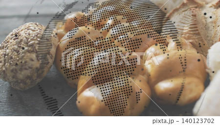 Displaying braided golden-brown loaf gleaming on wooden table, with seeded roll and halftone dots Displaying braided golden-brown loaf gleaming on wooden table, with seeded roll and halftone dots 140123702