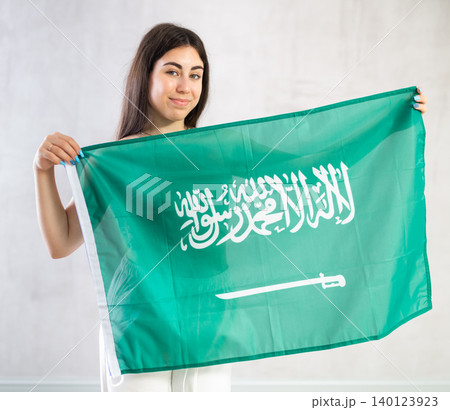 Young woman with flag of Saudi Arabia posing in studio Young woman with flag of Saudi Arabia posing in studio 140123923