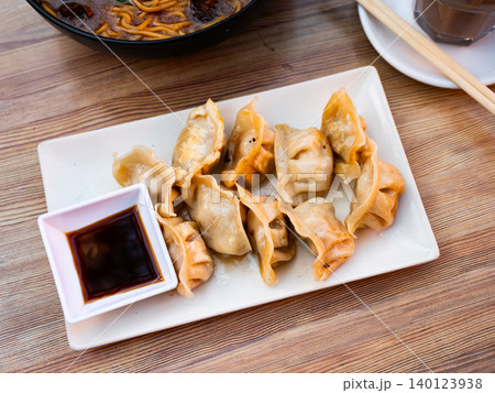 Grilled gyoza dumplings, bowl of soy sauce and chopsticks Grilled gyoza dumplings, bowl of soy sauce and chopsticks 140123938