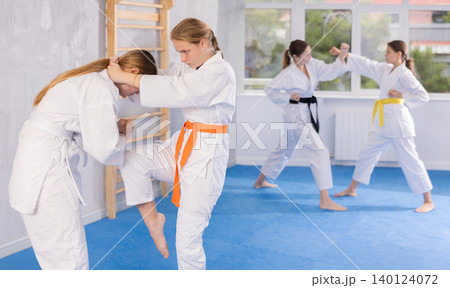 Females in kimono practicing fighting moves 140124072