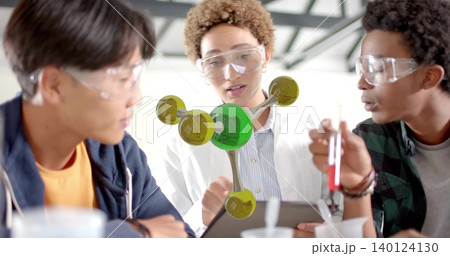 Pointing white lab coat student explaining AR molecular model at lab bench, holding test tube Pointing white lab coat student explaining AR molecular model at lab bench, holding test tube 140124130