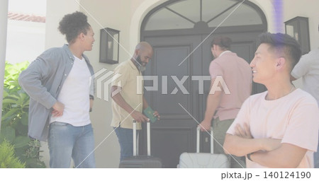 Smiling man in pink T-shirt standing arms crossed at stucco entry, holding passport and suitcases Smiling man in pink T-shirt standing arms crossed at stucco entry, holding passport and suitcases 140124190