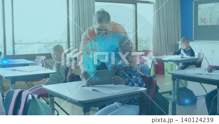 Leaning teacher in orange top and glasses assisting pupil at school desk with tablet hologram Leaning teacher in orange top and glasses assisting pupil at school desk with tablet hologram 140124239