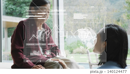 Holding hands adult in blue top and senior in maroon cardigan by window, viewing holographic charts Holding hands adult in blue top and senior in maroon cardigan by window, viewing holographic charts 140124477