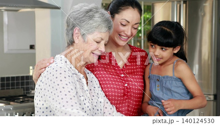Smiling three women in distinct clothes leaning over kitchen counter with gas stove and backsplash Smiling three women in distinct clothes leaning over kitchen counter with gas stove and backsplash 140124530
