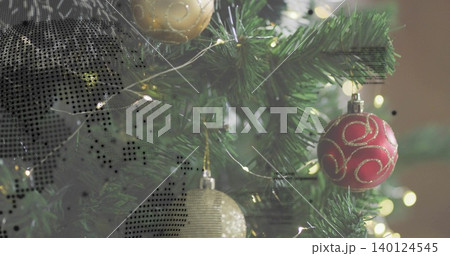 Showing trimmed fir branch glowing with lights at home, with red bauble, gold orb and halftone 140124545