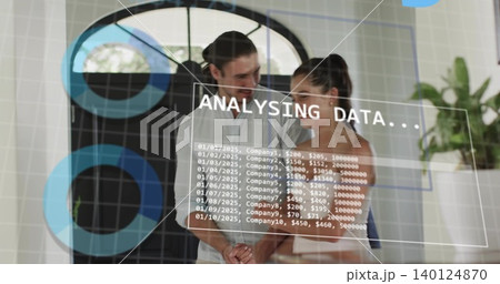 Studying man and woman in office wearing white shirt and sleeveless top analyzing data on glass 140124870