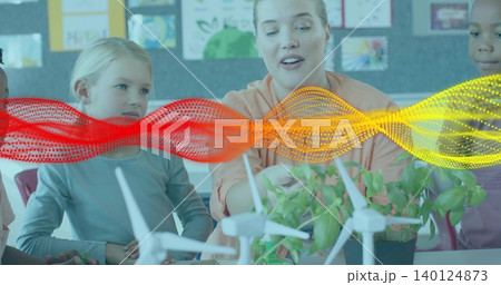 Showing teacher in peach top guiding group at school table, with white turbines, plant and waveform Showing teacher in peach top guiding group at school table, with white turbines, plant and waveform 140124873
