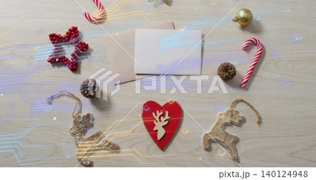 Showing red heart with white reindeer centred on wood table, envelopes, candy cane, circuit overlay Showing red heart with white reindeer centred on wood table, envelopes, candy cane, circuit overlay 140124948
