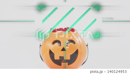 Displaying orange pumpkin bucket with black handles on tabletop showing glossy red candies AR 671 Displaying orange pumpkin bucket with black handles on tabletop showing glossy red candies AR 671 140124953