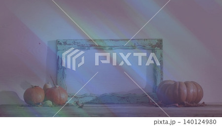 Showing distressed wood frame leaning on painted wall, with pumpkins, dried leaves, prism streaks Showing distressed wood frame leaning on painted wall, with pumpkins, dried leaves, prism streaks 140124980